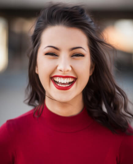 a smiling woman with red lipstick and shirt