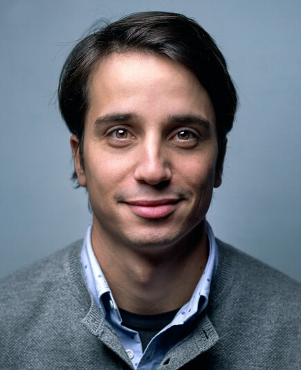 a smiling guy wearing a gray t-shirt